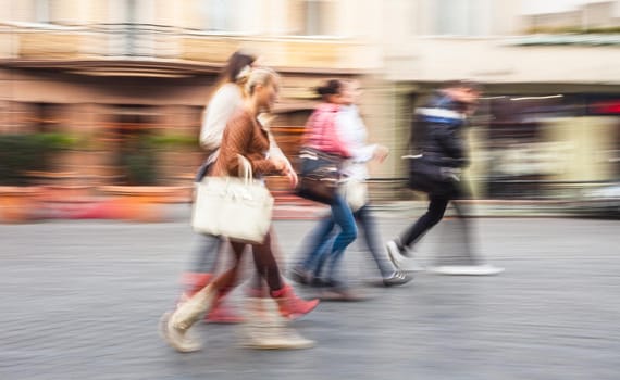 A group of young people going along the street. Intentional motion blur