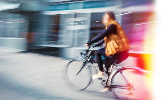 Cyclist on the city roadway in motion blur. Vintage filter with intentional color shift
