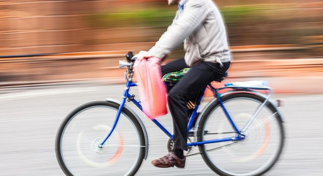 Abstract blurred image of cyclist on the city roadway. Intentional motion blur