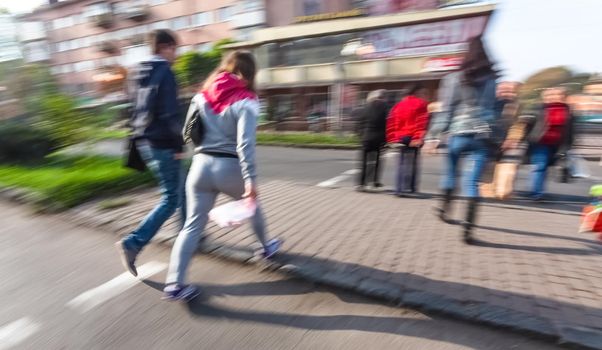 City life concept. People rushing in city. Abstract street scene in motion blur. Group of people at a pedestrian crossing