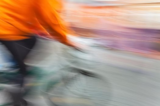 Abstract blurred image of cyclist on the city roadway. Intentional motion blur