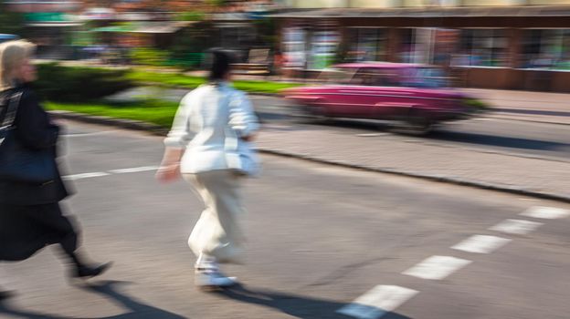 City life concept. People rushing in city. Abstract street scene in motion blur. Group of people at a pedestrian crossing