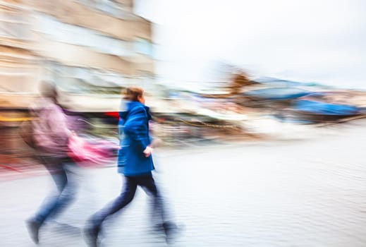 Abstract soft focus image of a group of young people hurrying about their business. Intentional motion blur