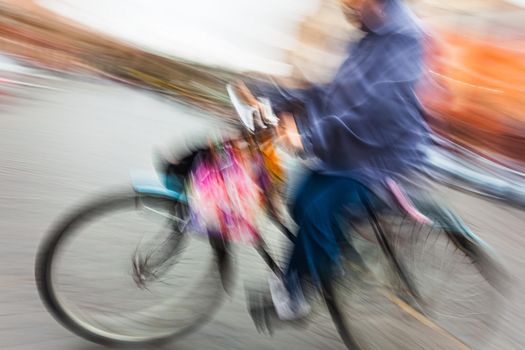 Abstract blurred image of cyclist on the city roadway. Intentional motion blur