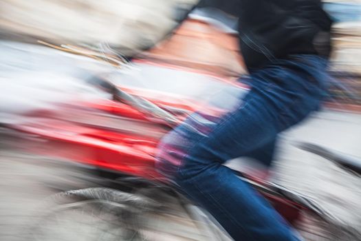 Abstract blurred image of cyclist on the city roadway. Intentional motion blur