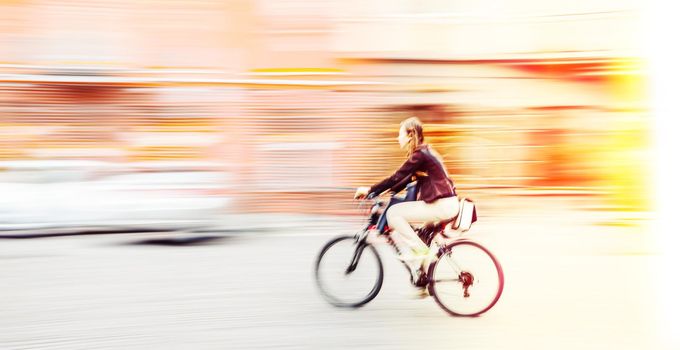 Abstract blurred image of cyclist on the city roadway. Intentional motion blur