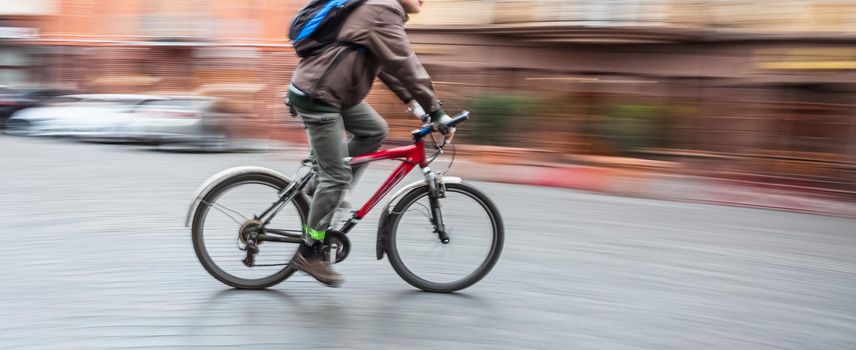 Abstract blurred image of cyclist on the city roadway. Intentional motion blur