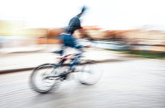 Abstract blurred image of cyclist on the city roadway. Intentional motion blur