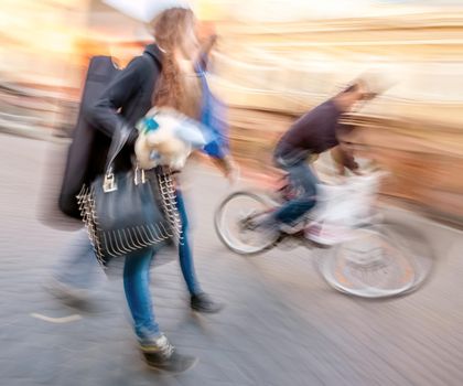 Young people and cyclist going about their business. Street scene with intentional motion blur.