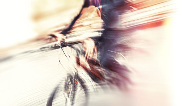 Abstract blurred image of cyclist on the city roadway. Intentional motion blur