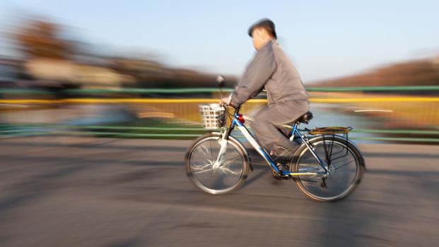 Abstract blurred image of cyclist on the city roadway. Intentional motion blur
