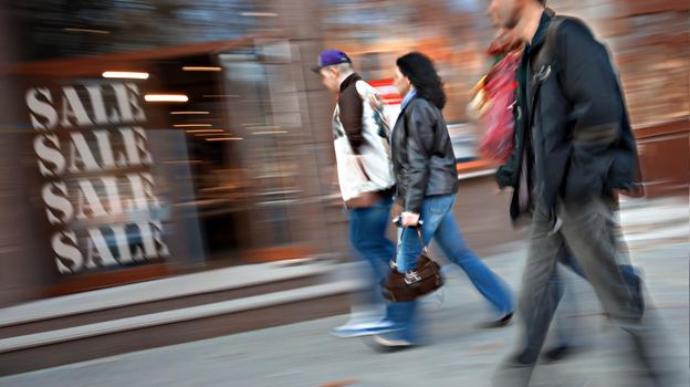 Group of people go to the store on sale. Intentional motion blur