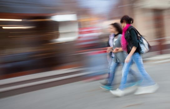 Abstract image of young people group going along the street. Intentional motion blur