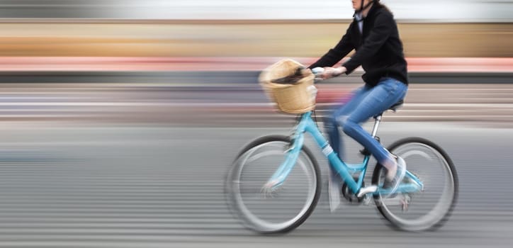 Abstract image of cyclist on the city roadway. Intentional motion blur and color shift