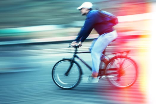 Abstract image of cyclist on the city roadway. Intentional motion blur and color shift