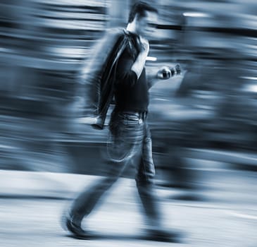Man talking on a cell phone in a hurry. Intentional motion blur and color shift