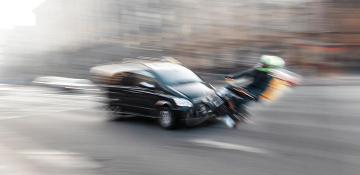 Dangerous city traffic situation with motorcyclist and car in the city in motion blur