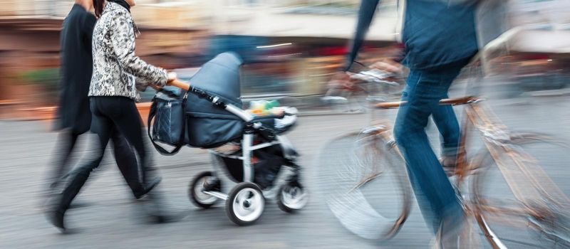 Dangerous situation on the road. Cyclist a second before a collision with a pram.  Intentional motion blur