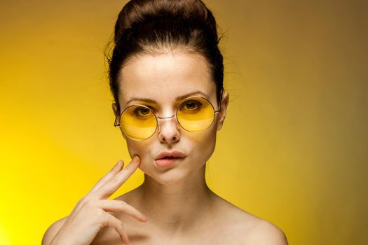 brunette with bare shoulders yellow glasses attractive look passion. High quality photo