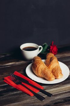 fresh croissant on a plate kitchen utensils coffee cup. High quality photo