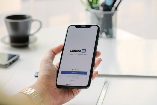 CHIANG MAI, THAILAND, MAR 7, 2020 : A women holds Apple iPhone Xs with LinkedIn application on the screen.LinkedIn is a photo-sharing app for smartphones.