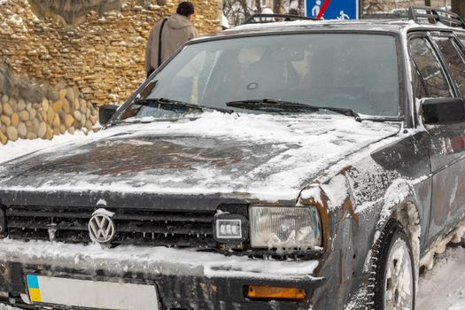 Lutsk, Ukraine - February 12,2020: Road salt harms car. Salt on the roads. Corrosion on a frozen auto. Car rust in winter. Uncleaned road. Negative effects of using road salt. Winter damage on vehicle