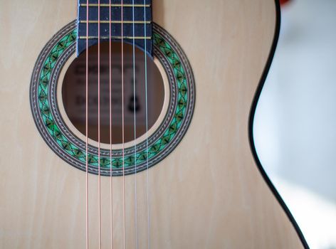 Close-up of a guitar player or a person learning to play an acoustic guitar. Home learning to play a musical instrument