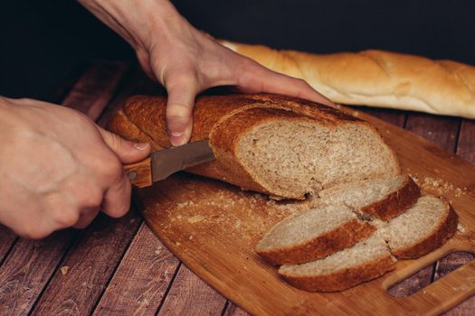cutting a fresh loaf on a cutting board crispy bread kitchen meal. High quality photo