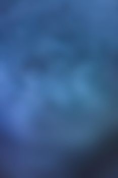 Defocused blurred image of blue smoke on dark background. Texture and abstract art