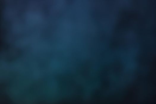Defocused blurred image of colorful smoke on dark background. Texture and abstract art