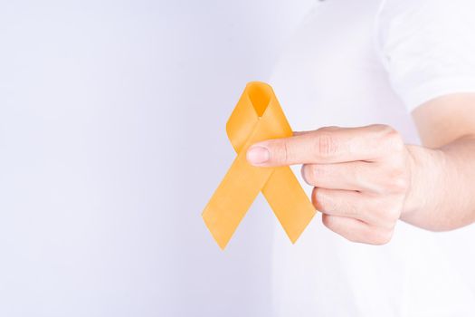 World kidney day, hands holding orange ribbon awareness of kidney disease on chest isolated white background.