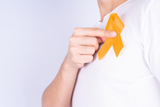 World kidney day, hands holding orange ribbon awareness of kidney disease on chest isolated white background.