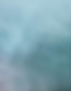 Defocused blurred image of colorful smoke on dark background. Texture and abstract art