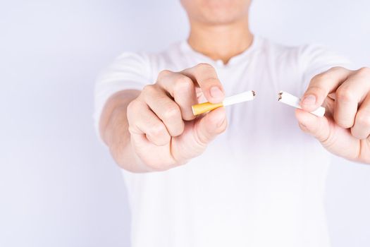 Male hand breaking or crushing cigarette. World no Tobacco and stop smoking day.