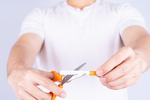 Male hand using scissors cutting cigarette. World no Tobacco and stop smoking day.