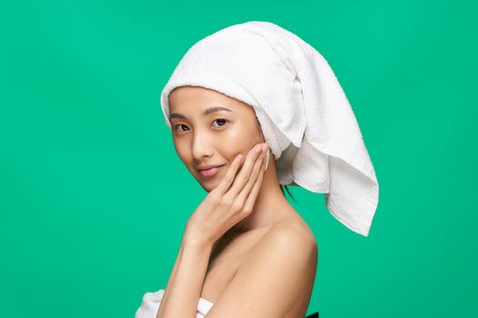 woman of asian appearance towel on head clean skin cropped view green background. High quality photo