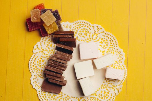 marmalade multicolored candy chocolate sweets dessert on a yellow background. High quality photo