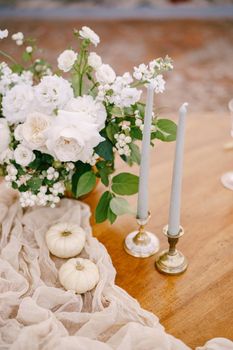 A close-up of a wooden table decorated for a wedding dinner.