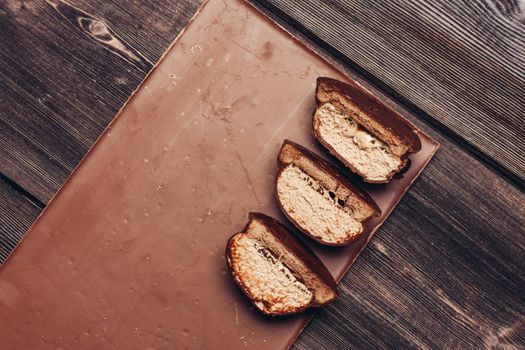 halved brownie and chocolate bar on wooden table. High quality photo
