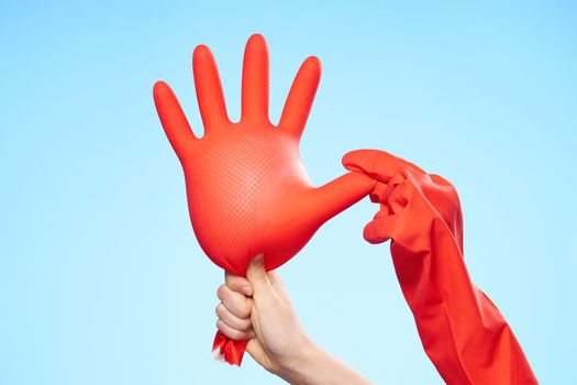 inflated rubber glove in hand house cleaning blue background. High quality photo