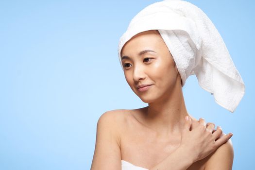 pretty asian woman clean skin care towel on head blue background. High quality photo