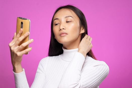 asian woman holding phone he communication technology internet pink background. High quality photo