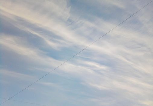 Blue sky with clouds and electric wire.