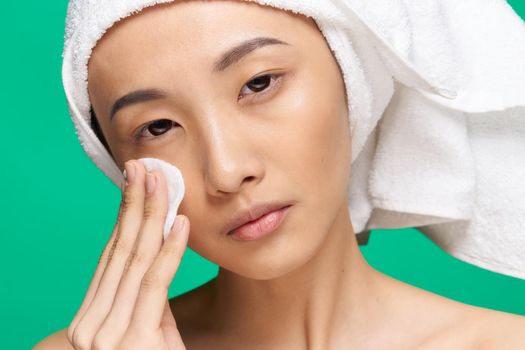 woman asian appearance clean skin close-up spa treatment green background. High quality photo