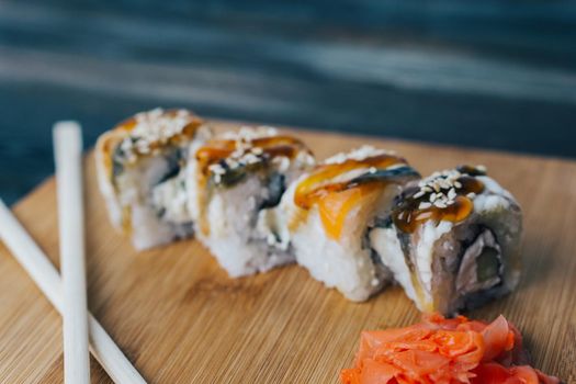sushi rolls chopsticks see wood board food assortment. High quality photo