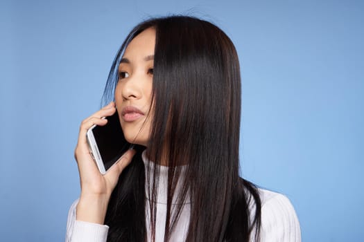 woman asian appearance phone communication technology lifestyle blue background. High quality photo