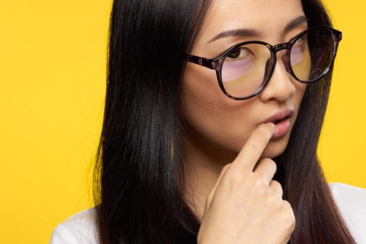 woman of asian appearance glasses attractive look holds finger on lips. High quality photo
