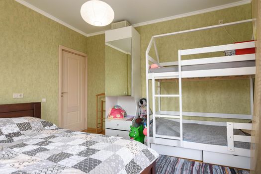 Bedroom interior with a large double bed and a children's bunk bed