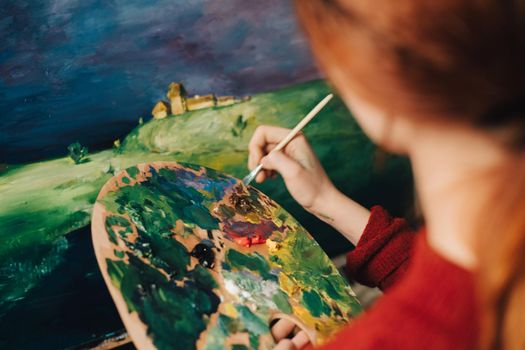 the artist paints a picture on an easel palette image. High quality photo