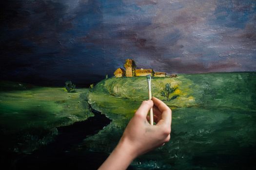 woman artist paints a picture with bright colors on an easel and canvas palette. High quality photo